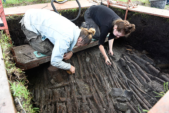 Archäologen bei der freilegung eines Bohlenwegs