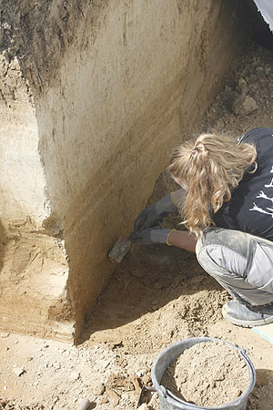 Studentin bei der Präparierung des geologischen Profils, um die Fundschichten sichtbar zu machen.