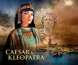 Das Ausstellungsmotiv Caesar & Kleopatra zeigt zwei Brustbilder vor einer antiken Stadt