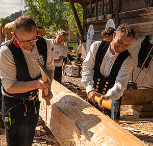 Zimmerhandwerk nach alter Tradition: Die Balken werden mit dem Beil bearbeitet